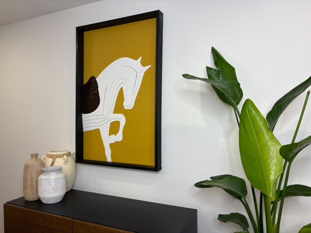 Framed white horse wall art on a yellow background